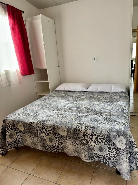 una camera da letto con un letto con un piumone bianco e nero di Sunset Village a Marina di Montenero