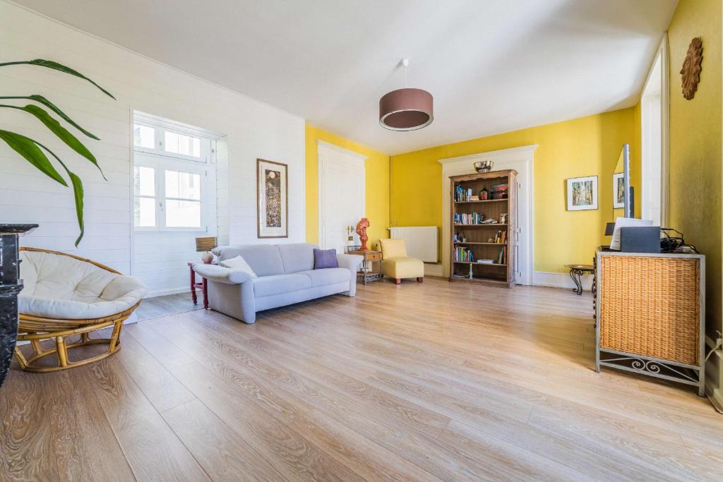 a living room with a couch and a tv at La Villa Lumière - 3 chambres in Tulle