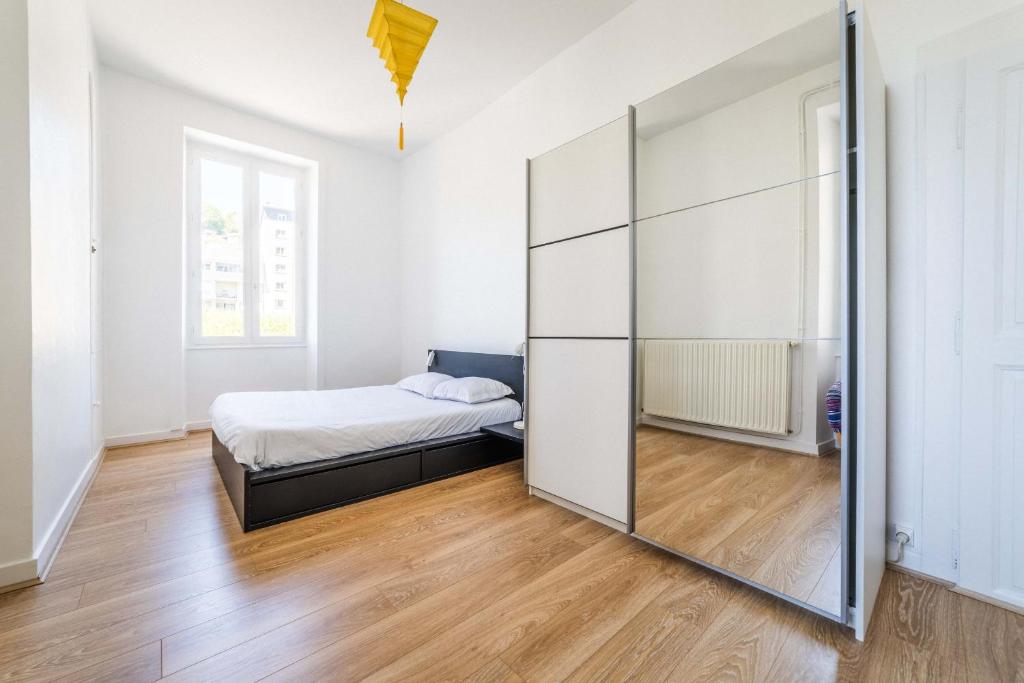 Schlafzimmer mit einem Bett und einem Spiegel in der Unterkunft Maison cozy - 3 chambres - Tulle in Tulle