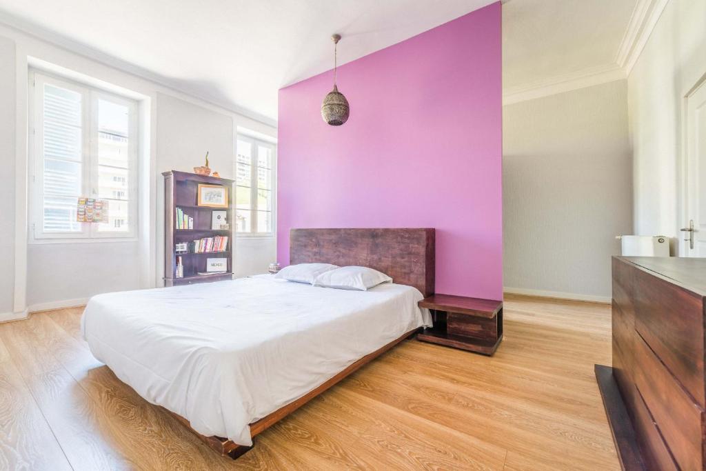 ein Schlafzimmer mit einer lila Wand und einem Bett in der Unterkunft Maison cozy - 3 chambres - Tulle in Tulle