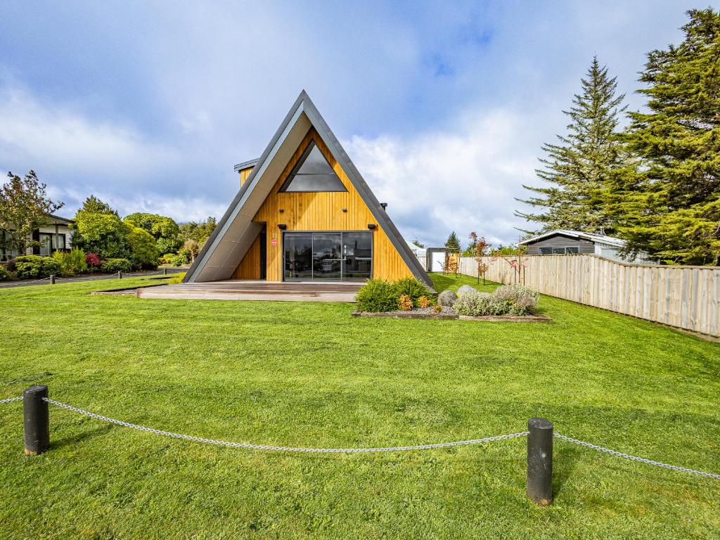 uma casa com um telhado triangular num quintal em Findlay Chalet - National Park Holiday Home em National Park