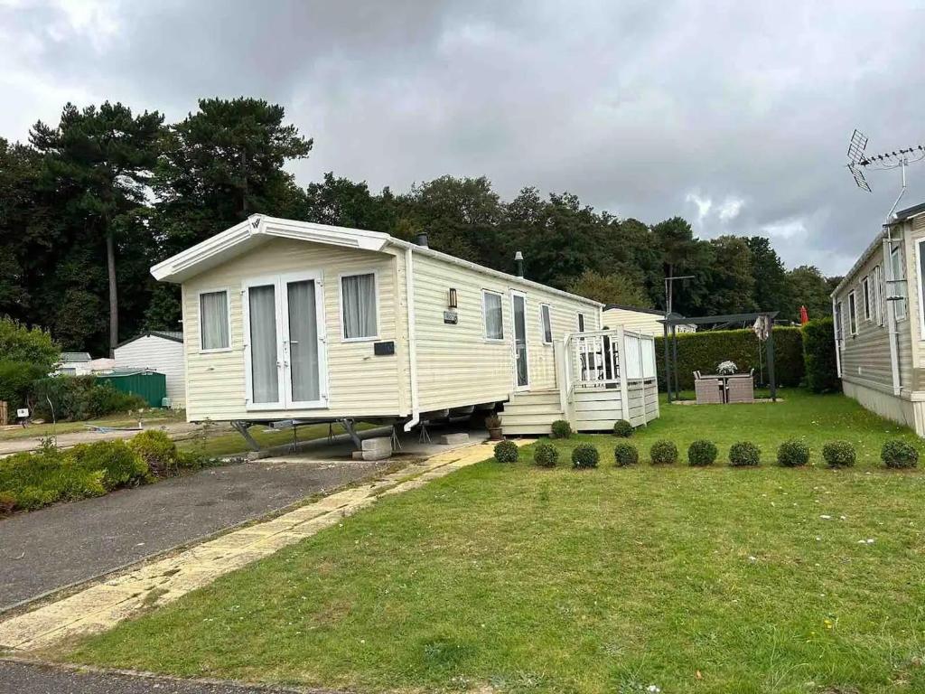 a white mobile home parked in a yard at Lakeside Escape Modern 2 Bedroom Holiday Home in Overstone