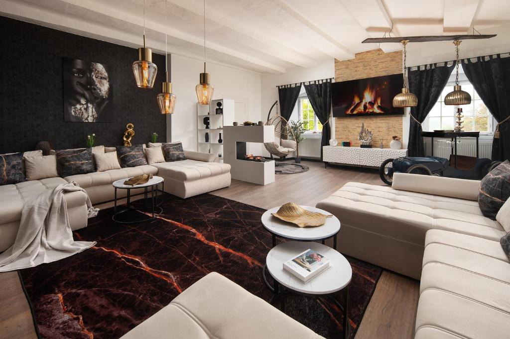 Una sala de estar con muebles blancos y chimenea. en Luxus wohnen im Schloss Corvey für 1-6 Gäste im UNESCO Weltkulturerbe Höxter Weserbergland free W-Lan Parken Netflix für Familien Paare und Geschäftsreisende inkl Handtücher Seife Nintendo Switch uvm, en Höxter