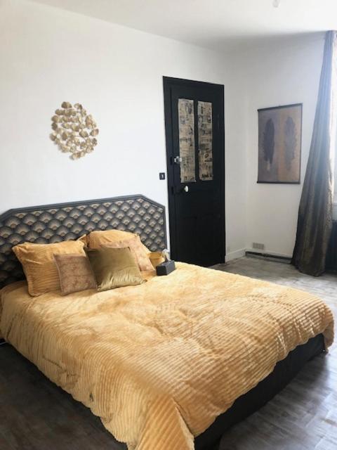 1 dormitorio con 1 cama grande con manta amarilla en Chambre dorée, en Pleurtuit