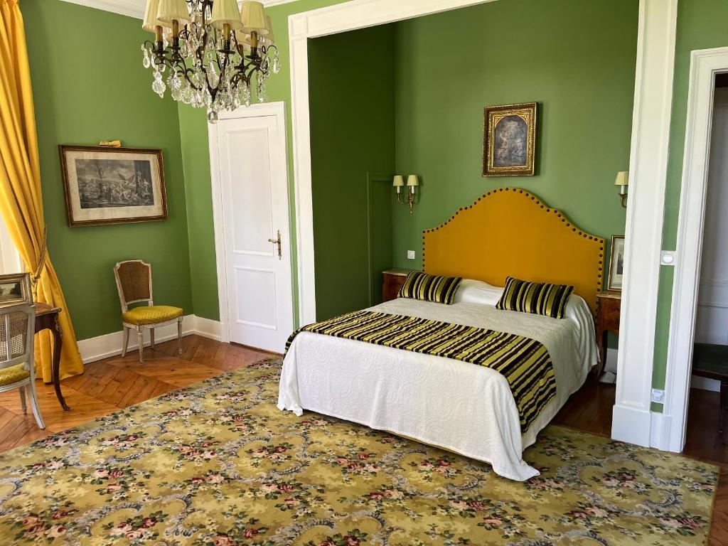 een slaapkamer met een bed met groene muren en een tapijt bij Chateau de Saint Aubin in Thiberville