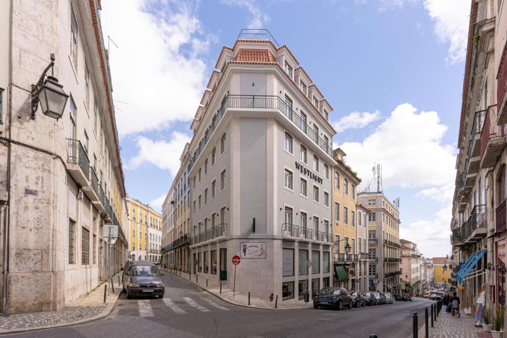 un grand bâtiment blanc dans une rue de la ville dans l'établissement Westlight Lisboa Madalena, à Lisbonne