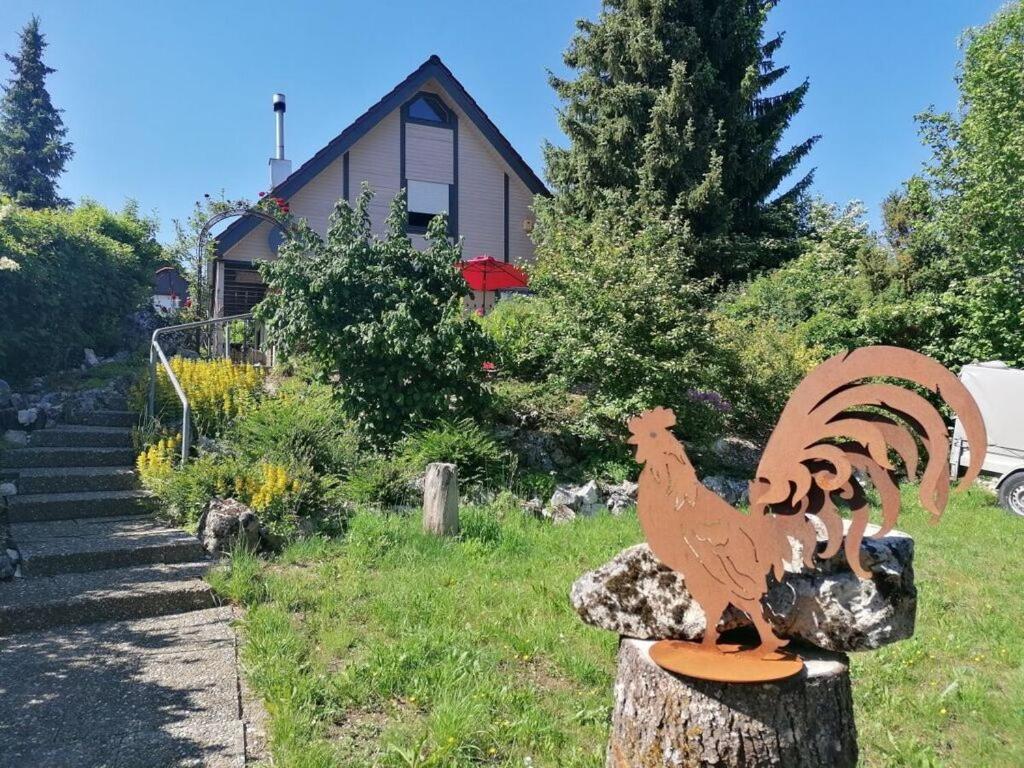 un pollo di legno su un tronco d'albero di fronte a una casa di Holiday home Danube Valley 