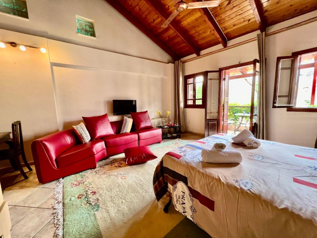um quarto com uma cama grande e um sofá vermelho em Στούντιο Κέντρου Άνω πόλης Πάτρας em Patra