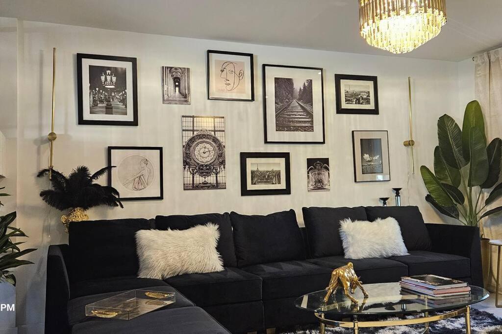 a living room with a black couch and pictures on the wall at Refreshing POOL Old Town Scottsdale 4 Bdr 3 FULL Baths in Scottsdale
