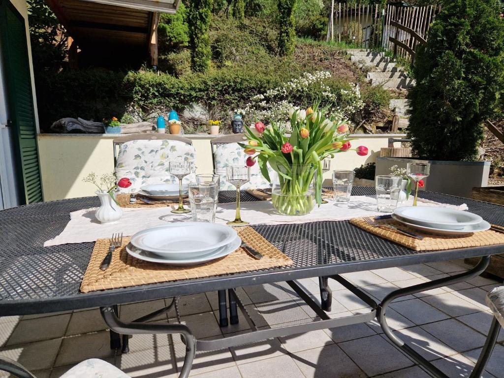 einen Tisch mit Platten und eine Vase Blumen darauf in der Unterkunft Ferienwohnung Leitnhax in Berchtesgaden
