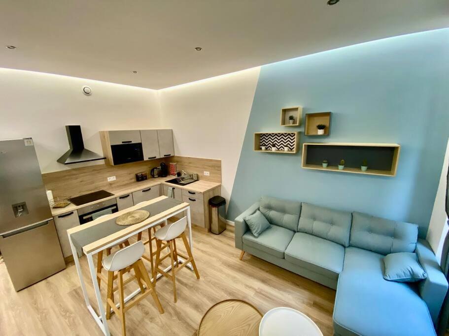 un salon avec un canapé bleu et une cuisine dans l'établissement Appart Moderne coeur de ville, à Toulon