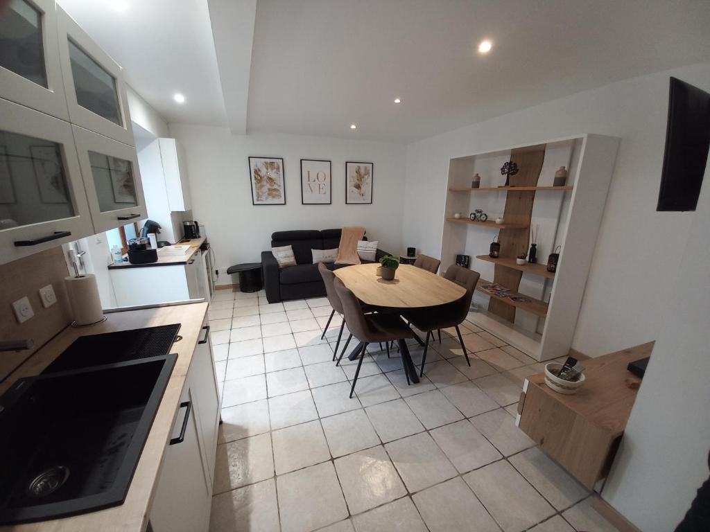 eine Küche und ein Wohnzimmer mit einem Tisch und einem Sofa in der Unterkunft Appartement cosy au cœur du centre ville in Bourges