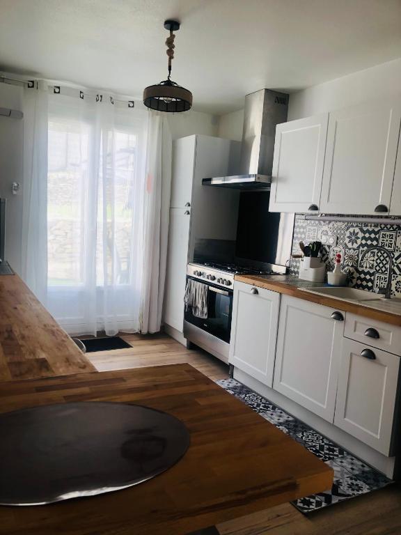 une cuisine avec des armoires blanches et un four à plaques de cuisson dans l'établissement La movida, à Aujargues