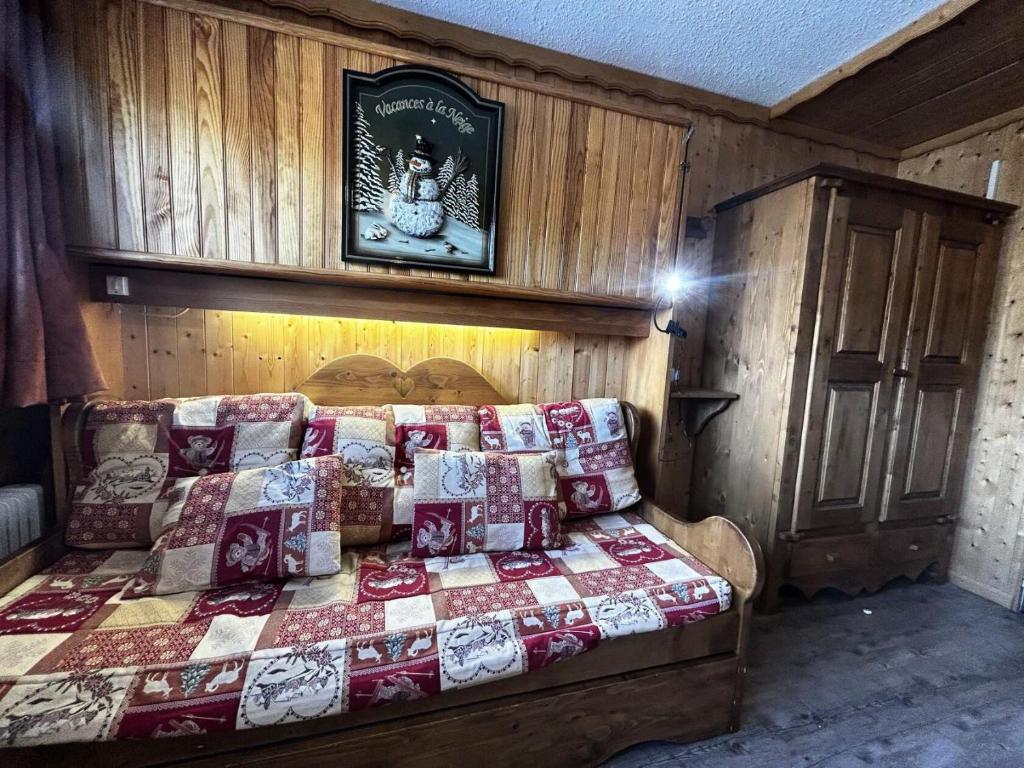 une chambre avec un lit avec une couette dessus dans l'établissement Résidence Tougnette - Studio équipé ski aux pieds aux Ménuires MAE-4004, aux Menuires