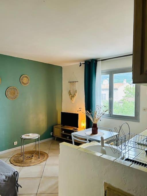 - un salon avec des murs verts et une table dans l'établissement Le Studio Cosy *Place du village, aux Salles-sur-Verdon