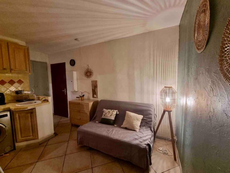 a living room with a couch and a kitchen at Le Studio Cosy *Place du village in Les Salles-sur-Verdon