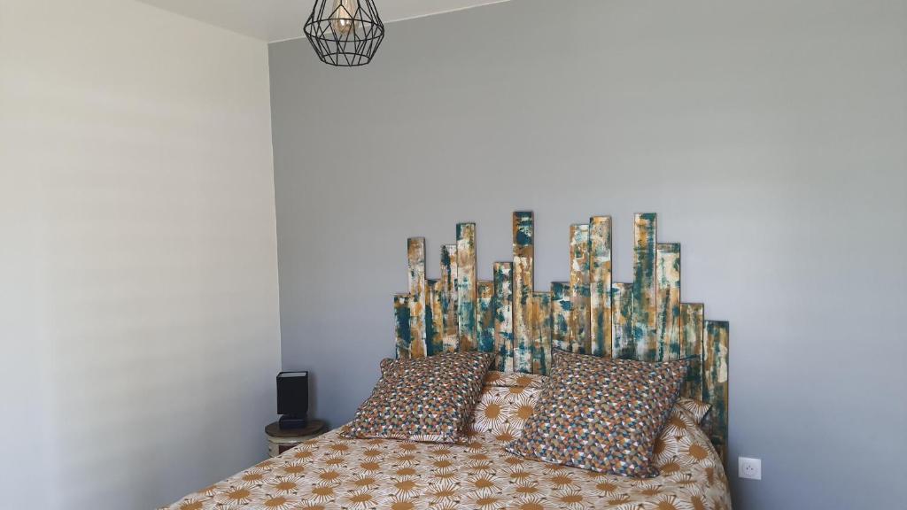 um quarto com uma cama com almofadas em CHAMBRE MEUBLEE LIT 2 PERSONNES em Le Poiré-sur-Vie