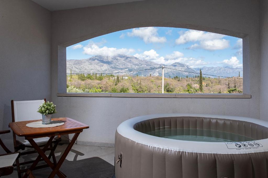 een bad in een kamer met een groot raam bij Dubrovnik Airport Apartment Tea in Durovići