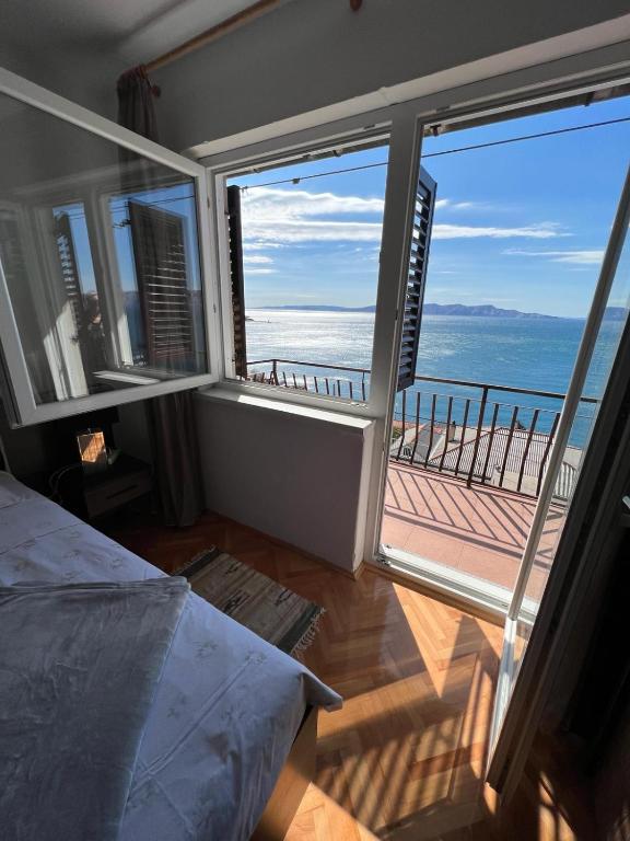 a bedroom with a view of the ocean from a balcony at Apartment Ivanka in Senj