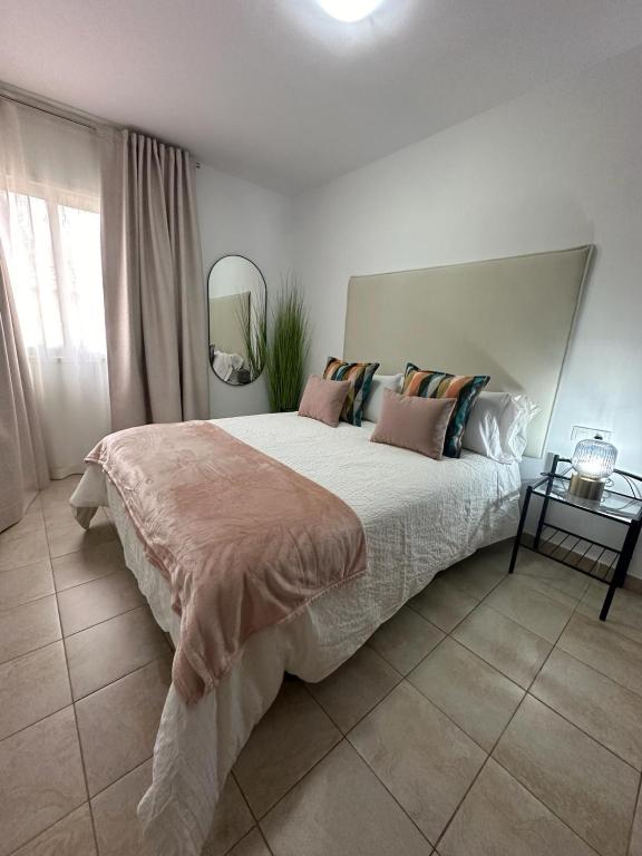 Un dormitorio con una cama grande con almohadas. en Casa Adriana, en San Isidro