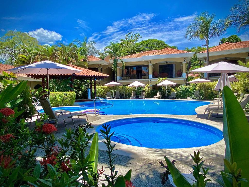 - une piscine avec des parasols et un complexe dans l'établissement Monte Carlo Luxury Condominiums, à Jacó
