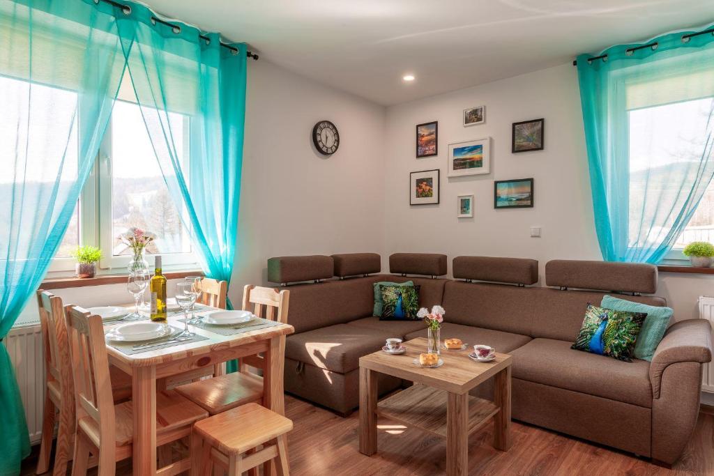 sala de estar con sofá y mesa en Apartamenty Za Świerkami, en Tylicz