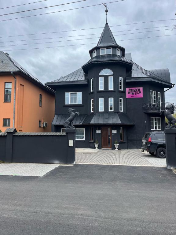 a black building with a tower on top of it at Broken bed hootel in Kaunas