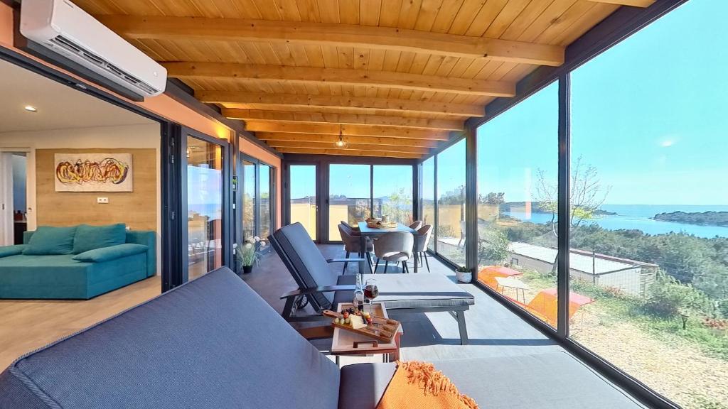 an open living room with a view of the ocean at Kasthouse Luxury mobile home Orange in Mali Lošinj