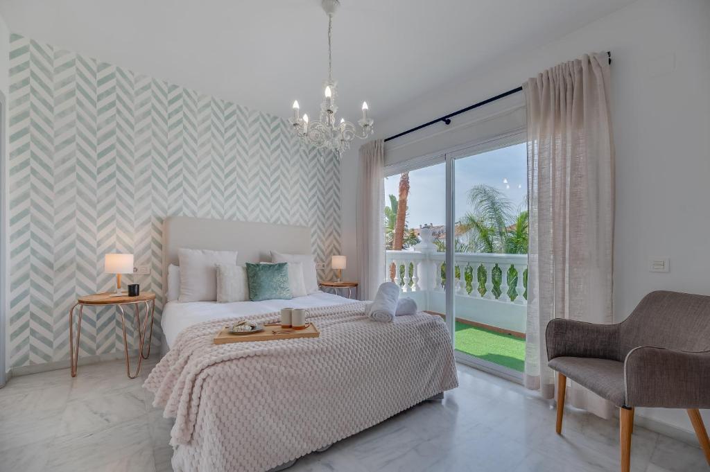 a white bedroom with a bed and a balcony at VACATION MARBELLA I Sunny Camelia Villa Heated pool in Benalmádena
