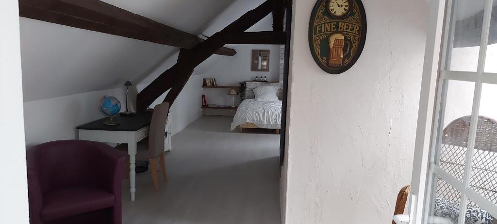 Cette chambre comprend un lit et une horloge murale. dans l'établissement La chambre de la maison du four à pain, à Grandchamp