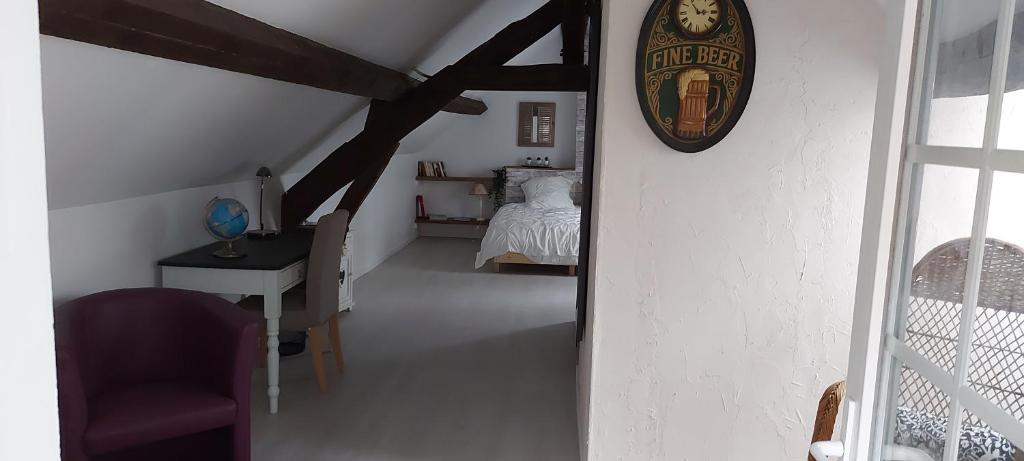 Zimmer mit einem Bett und einer Uhr an der Wand in der Unterkunft La chambre de la maison du four à pain in Grandchamp