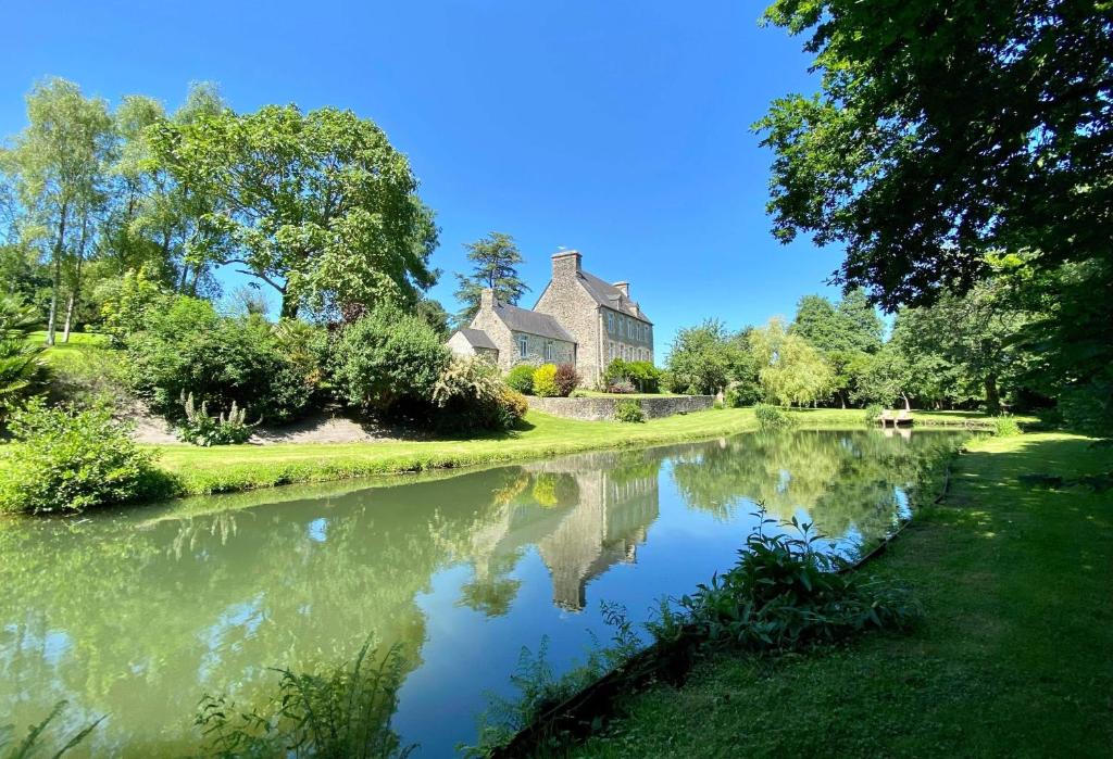 une maison et une rivière devant une maison dans l'établissement Au bord de l'étang - Le Presbytère, à Montaigu