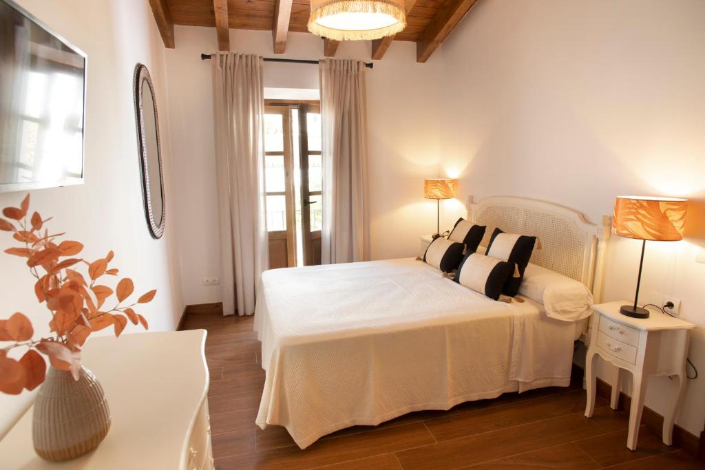 una camera da letto con un grande letto bianco e un tavolo di Casa Rural Candelas a Zahara de la Sierra
