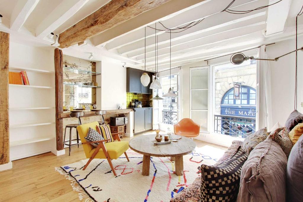 een woonkamer met een bank en een tafel bij Beautiful studio in the heart of the Latin Quarter in Parijs