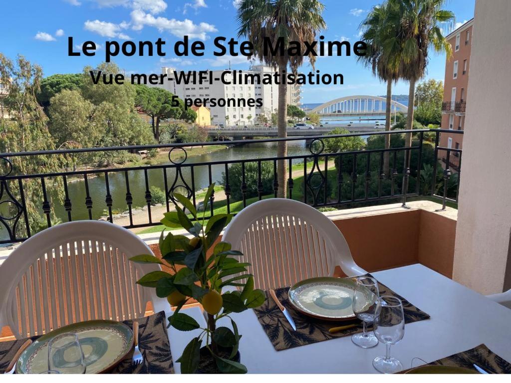 Una mesa con dos sillas y un balcón con vista. en Ste Maxime T3 Terrasse vue mer et avec piscine, en Sainte-Maxime