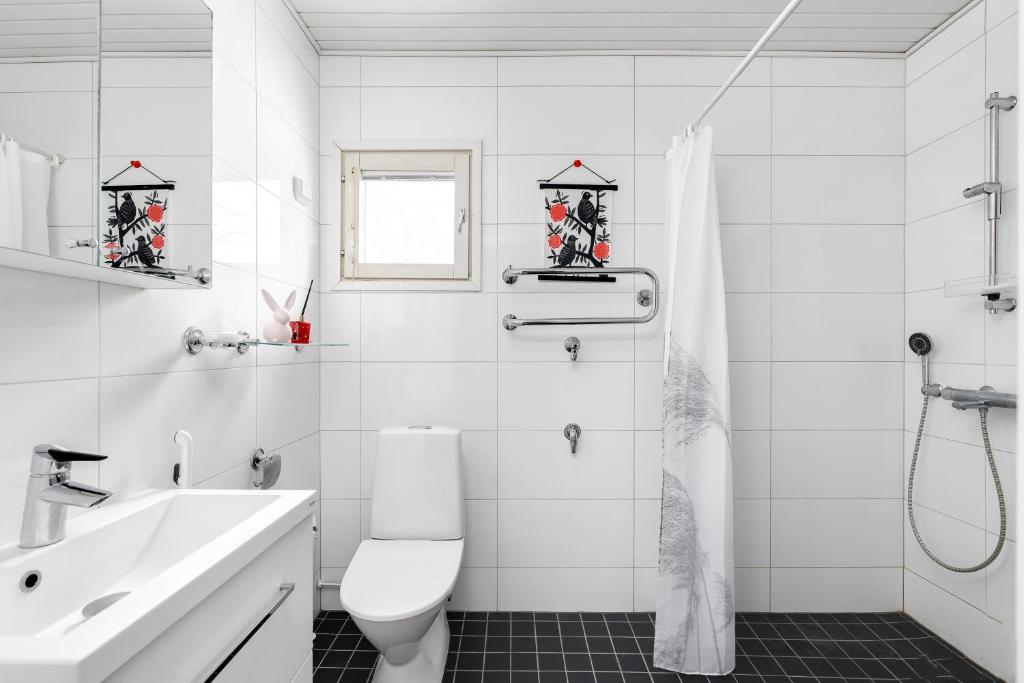 a white bathroom with a toilet and a sink at Private rooms near metro, free parking in Helsinki