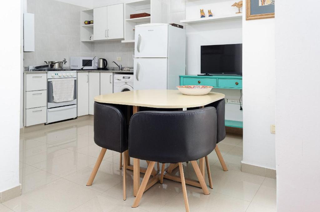 uma cozinha com uma mesa e duas cadeiras pretas em ¡Tu segundo hogar en Santiago del Estero! Descubrí este pequeño encantador departamento em Santiago del Estero