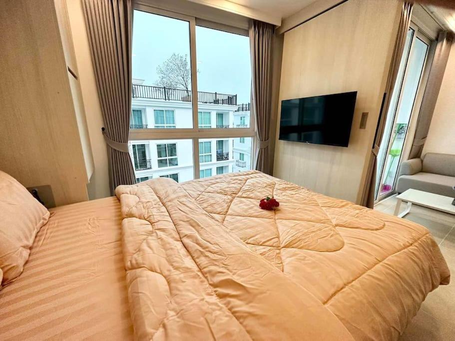 Una cama grande en un dormitorio con una ventana grande. en Free Power&WiFi,Work Remotely, Kitchen,Deal, en Pattaya South