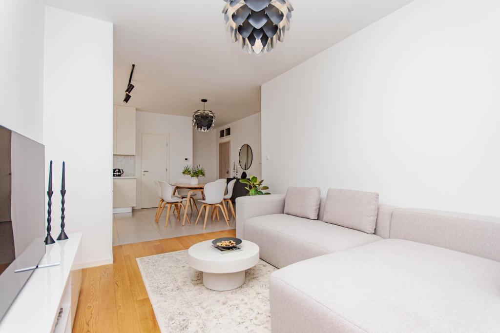 a white living room with a couch and a table at A Riduli in Split