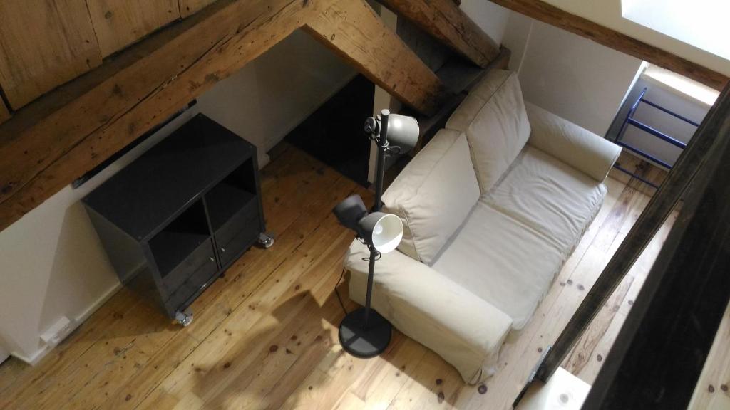 an overhead view of a living room with a white couch at Studio meublé proche conseil départemental du Jura in Lons-le-Saunier