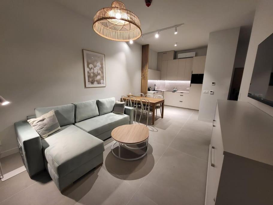 a living room with a couch and a table at Apartament na wydmie in Mrzeżyno