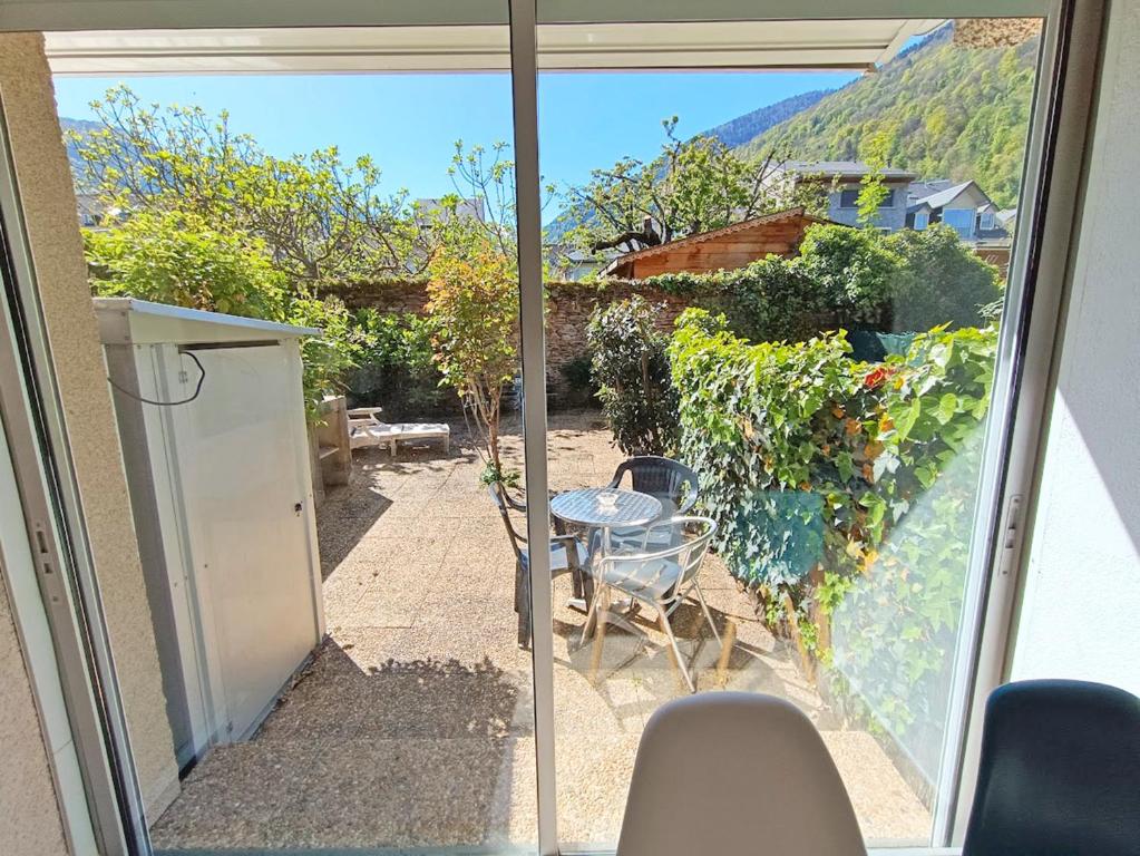 een uitzicht op een patio vanuit het raam van een huis bij Le Sentein, T2, centre, parking, jardin, 2 personnes in Luchon