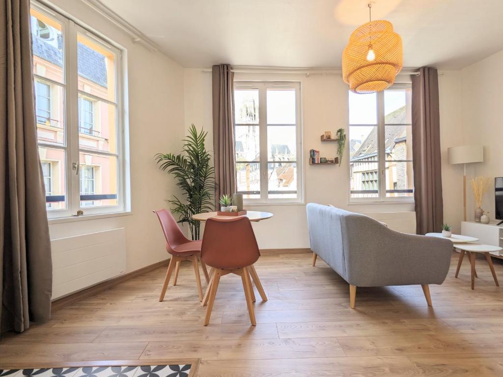 een woonkamer met een tafel, stoelen en ramen bij Le Perchoir - Studio vue imprenable - Hypercentre in Rouen