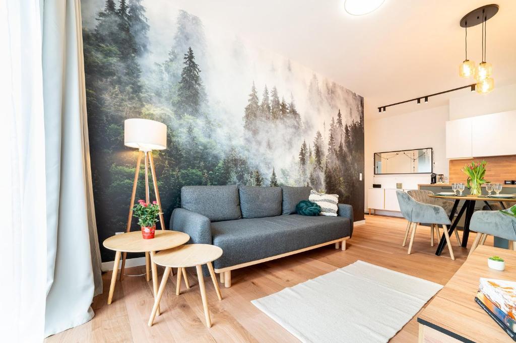 ein Wohnzimmer mit einem Sofa und einem Gemälde an der Wand in der Unterkunft Apartament Śnieżne Kotły Ostoja Parku Narodowego in Szklarska Poręba
