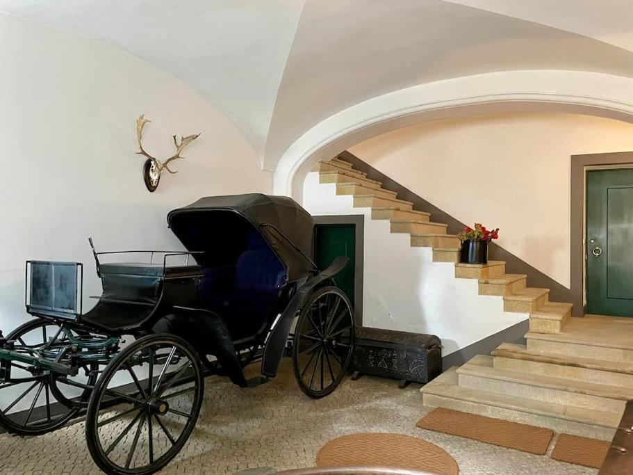 un carruaje tirado por caballos en una sala de estar con escaleras en Casa da Lagoa, en Évora