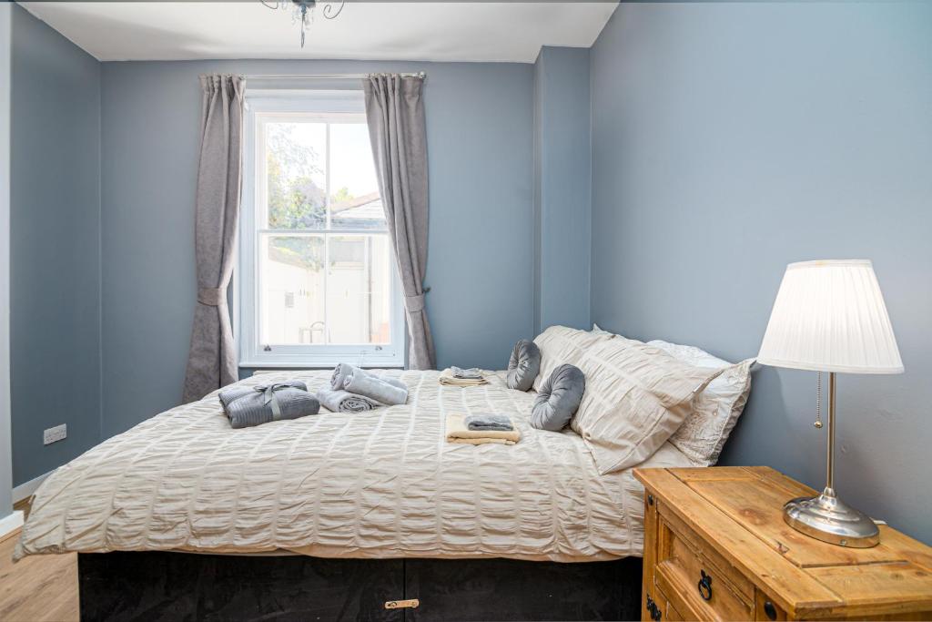 倫敦的住宿－SIDNEY，一间卧室配有一张蓝色墙壁的床和一扇窗户