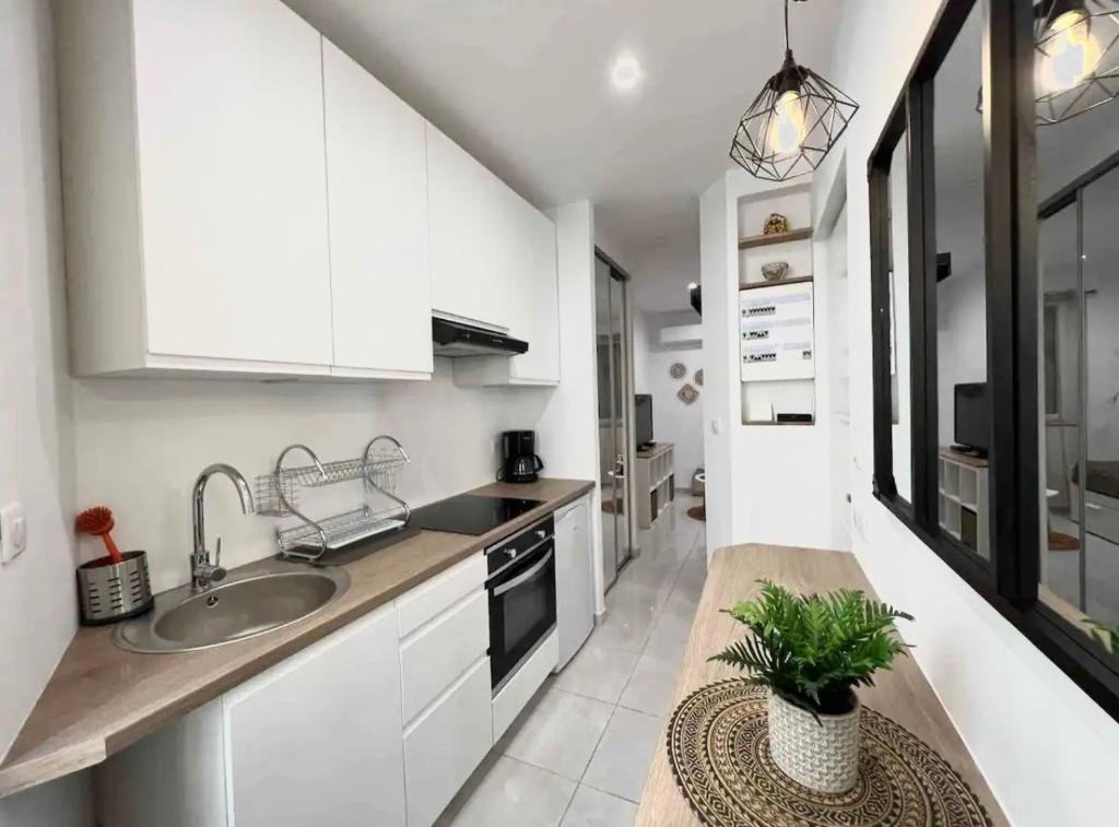 a kitchen with white cabinets and a sink at Cosy Studio *Vieux-Port* in Marseille