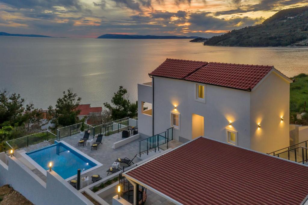 a house with a swimming pool next to a body of water at Villa No stress in Drasnice