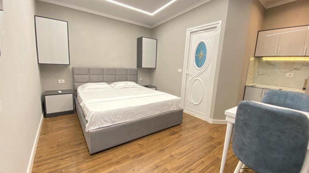 a bedroom with a bed and a desk and a chair at Guest house Luli Strumi in Berat
