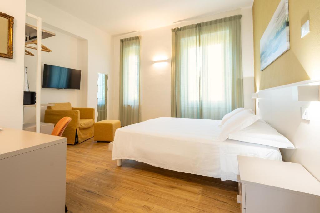 ein Schlafzimmer mit einem weißen Bett und ein Wohnzimmer in der Unterkunft Le camere sui colli 2 in La Spezia